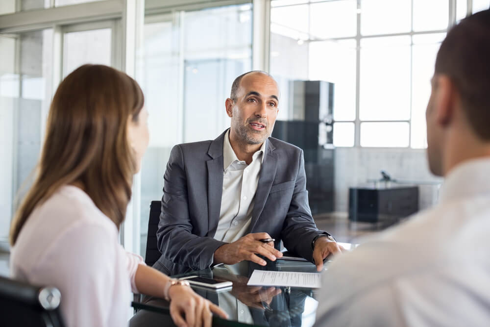 A business professional signing life insurance documents, symbolizing financial planning and future security.